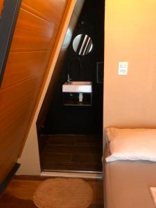 a small bathroom with a sink and a bed at Chalé estilo in Chapada dos Guimarães