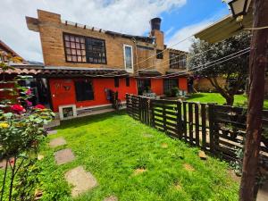 a house with a fence in front of a yard at El Peregrino in Cota