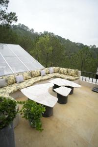 two benches sitting on top of a roof at Van Rāsa in Kasauli +14 photos