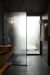 a glass door in a room with a window at Van Rāsa in Kasauli
