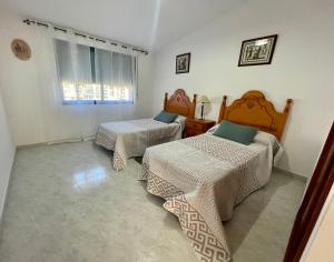 a bedroom with two beds and a window at Casa turística Lucena in Vilagarcia de Arousa