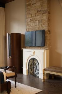 a living room with a fireplace with a tv above it at Van Rāsa in Kasauli