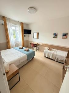 a bedroom with two beds and a desk in it at Melannie's Apartment 2 in Bergamo