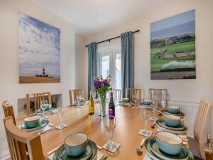 a dining room with a wooden table with chairs at Samphire in Bacton