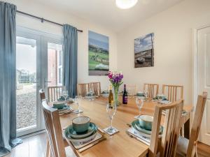 a dining room with a wooden table and chairs at Samphire in Bacton