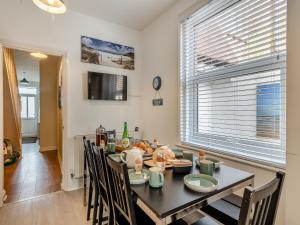 a dining room with a table and chairs and a window at Samphire in Bacton
