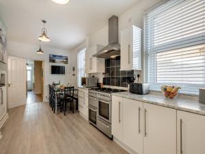 a kitchen with white cabinets and a counter top at Samphire in Bacton +24 photos