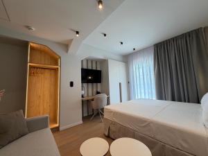 a bedroom with a bed and a couch and a desk at Local Urban Living in Volos