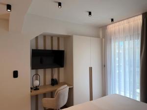 a bedroom with a bed and a tv and a window at Local Urban Living in Volos +35 photos