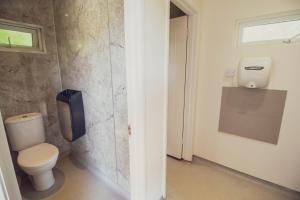 a bathroom with a toilet with a tv on the wall at Leto Shepherds Hut By Airpremier in Alfriston