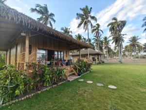 a house with a grass yard in front of it at Sumba Retreat Kerewe in Waikabubak