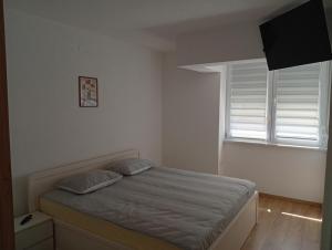 a bedroom with a bed with two pillows and a window at Vitez apartman in Vitez