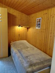 a bedroom with a bed in a wooden wall at Holiday Home Uckeritz - Seebad 1 in Ueckeritz