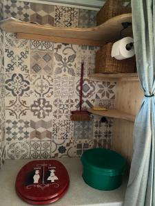 a corner of a room with a tiled wall at Tiny ou Petite maison sur roulettes in Le Fay
