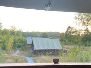 an old barn with a metal roof in a field at Tiny ou Petite maison sur roulettes in Le Fay +7 photos