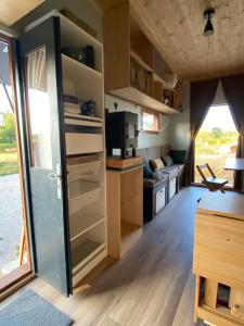 a kitchen with a door open in a tiny house at Tiny ou Petite maison sur roulettes in Le Fay
