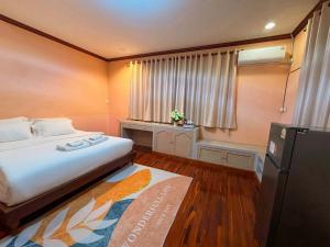 a small bedroom with a bed and a refrigerator at Kat's GuestHouse in Hua Hin +4 photos