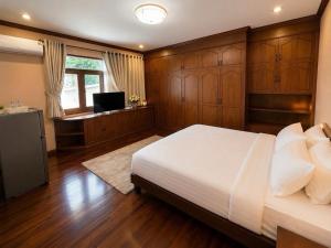 a bedroom with a bed and a desk and a television at Kat's GuestHouse in Hua Hin