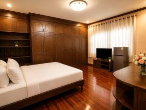 a large bedroom with a bed and a television at Kat's GuestHouse in Hua Hin