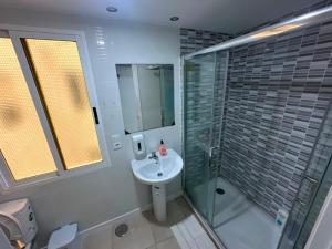a bathroom with a glass shower and a sink at Hostal Alegria Alicante in Alicante