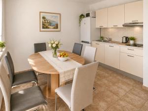 a kitchen and dining room with a table and chairs at Villa Jurisic in Tučepi