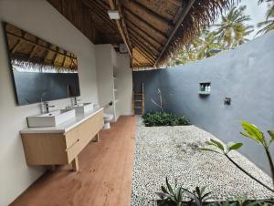 a bathroom with two sinks and a large wall at Sumba Retreat Kerewe in Waikabubak +118 photos