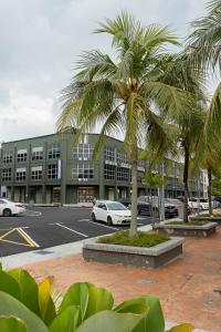 a parking lot with palm trees in front of a building at Hotel Valya Melaka Sentral Riverfront in Malacca