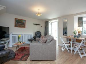 a living room with a couch and a table at Garden Cottage in Kingsbridge