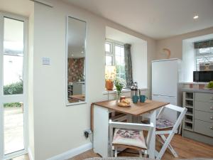 a kitchen with a table and chairs and a refrigerator at Garden Cottage in Kingsbridge