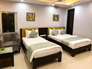 a hotel room with two beds and a chair at BHAGYA SHREE Hotel in Nokha