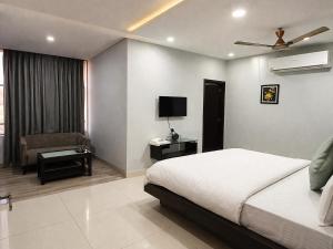 a bedroom with a bed and a chair and a television at BHAGYA SHREE Hotel in Nokha +2 photos