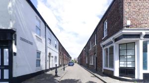 an alley with brick buildings and a car on a street at Delightful Durham Home in Gilesgate
