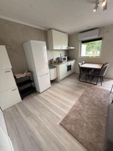 a kitchen with a white refrigerator and a table at Hindås Lakeside Cabin 4 in Hindås