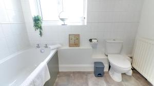 a bathroom with a white tub and a toilet at Delightful Durham Home in Gilesgate +30 photos
