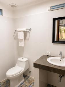 a white bathroom with a toilet and a sink at Abode Hotel Siem Reap in Phum Pobos +47 photos