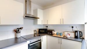 a white kitchen with white cabinets and appliances at Delightful Durham Home in Gilesgate
