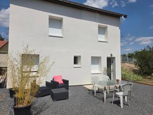 a white house with a table and chairs at Kity House maison individuelle avec jardin in Neufchâteau