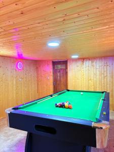 a pool table in a room with wooden walls at Otto's House in Ambrolauri