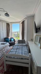 a living room with a bed and a couch at Spacious Triple Studio Room, Private En-Suite & Kitchenette R6 in Sketty