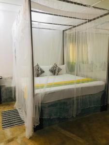 a bedroom with a canopy bed with white curtains at Villa Habarana in Habarana
