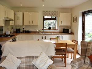 a kitchen with a table and a dining room at Brooklands Cottage in Bellerby
