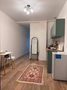 a kitchen with a refrigerator and a table and a rug at Bazaleti Lake Escape in Bazalet'i