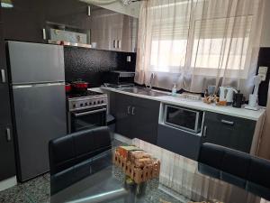 a kitchen with a stainless steel refrigerator and a stove at Renas home in Anavyssos