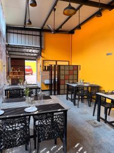 a restaurant with tables and chairs and a yellow wall at Hotel Grand Palais in Bangalore