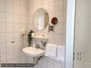 a bathroom with a sink and a mirror and towels at Hotel Falk in Bremen +33 photos