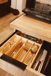 a wooden drawer with utensils in a kitchen at Apartament w Parku 5 in Żywiec