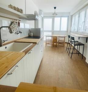a kitchen with white cabinets and a table with chairs at Apuliantales Cottage Bari in Carbonara di Bari
