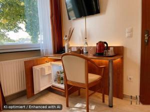 a kitchen with a desk with a chair and a small refrigerator at Hotel Falk in Bremen