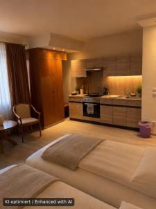 a bedroom with a large bed and a kitchen at Hotel Falk in Bremen