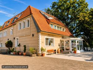 a building with an orange roof and a bench at Hotel Falk in Bremen